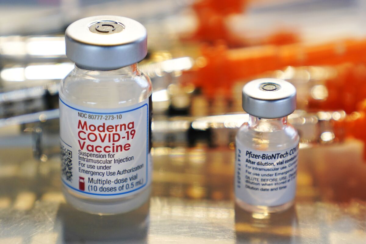 FILE - This Thursday, Feb. 25, 2021 file photo shows vials for the Moderna and Pfizer COVID-19 vaccines at a temporary clinic in Exeter, N.H. In September, 2021, the Food and Drug Administration approved extra doses of Pfizer’s original COVID-19 vaccine after studies showed it still works well enough against the delta variant. And the FDA is weighing evidence for boosters of the original Moderna and Johnson & Johnson vaccines. (AP Photo/Charles Krupa)