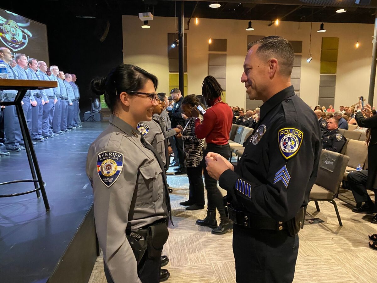 Natalie Young, 22, gets her new deputy badge pinned on by Escondido Police Sgt. Jeff Valdivia.