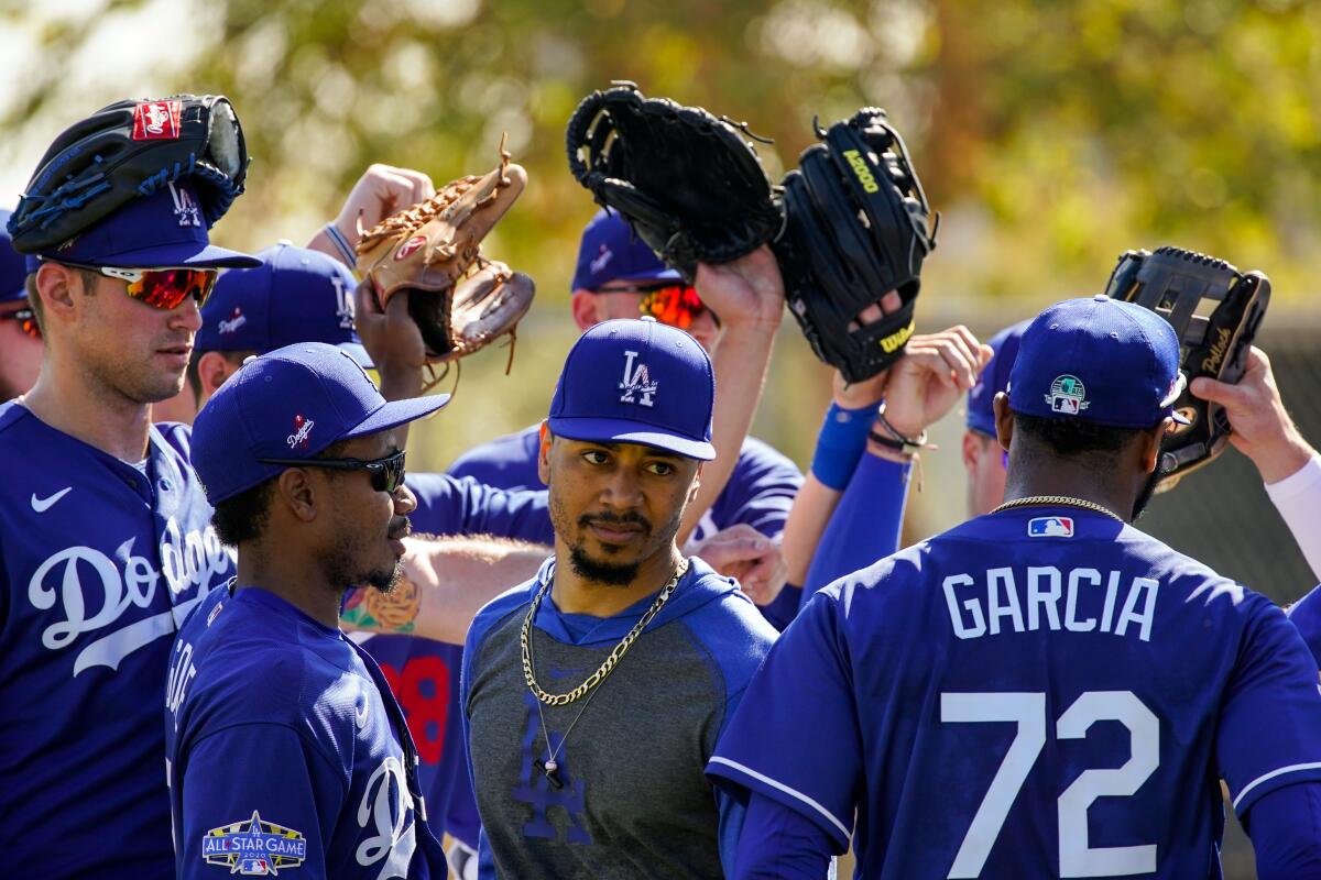 Dodgers right fielder Mookie Betts is surrounded by teammates during spring training at Camelback Ranch on Feb. 19.