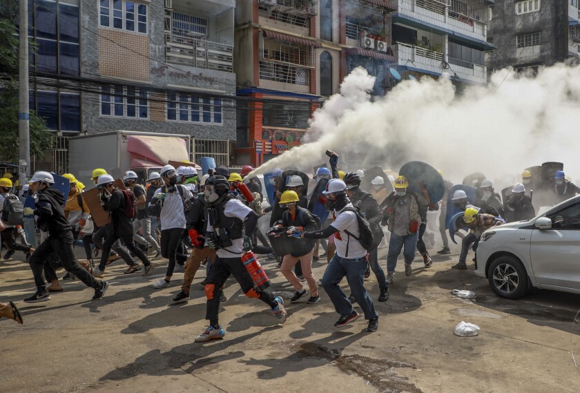 Anti-coup protesters run as one of them discharges a fire extinguisher to counter the impact of tear gas fired by riot policemen in Yangon, Myanmar, Wednesday, March 3, 2021. Demonstrators in Myanmar took to the streets again on Wednesday to protest last month's seizure of power by the military. (AP Photo)