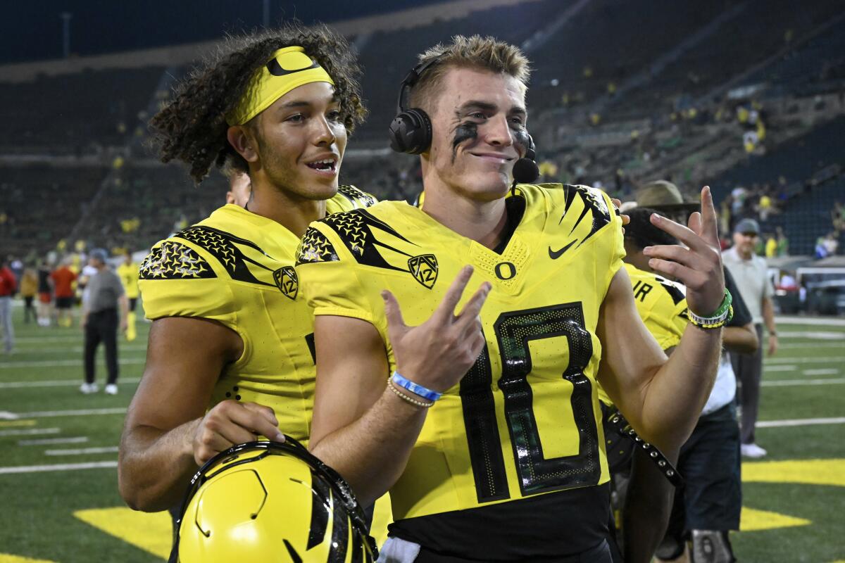 Oregon quarterback Ty Thompson (13) jokes with quarterback Bo Nix (10) after the team's 70-14 win over Eastern Washington in an NCAA college football game Saturday, Sept. 10, 2022, in Eugene, Ore. (AP Photo/Andy Nelson)