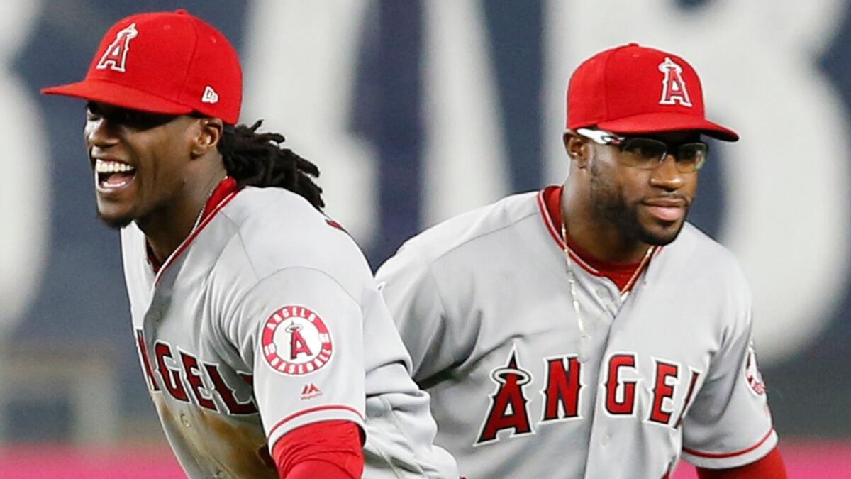 Angels outfielders Cameron Maybin, left, and Eric Young Jr. celebrate after a win over the New York Yankees on June 22.