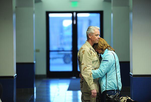 Capt. Edward Eidson and his wife, Joan, share a quiet moment before members of the Explosive Ordnance Disposal Group 1 depart for Iraq. Training military and police there is a major part of the job. See full story