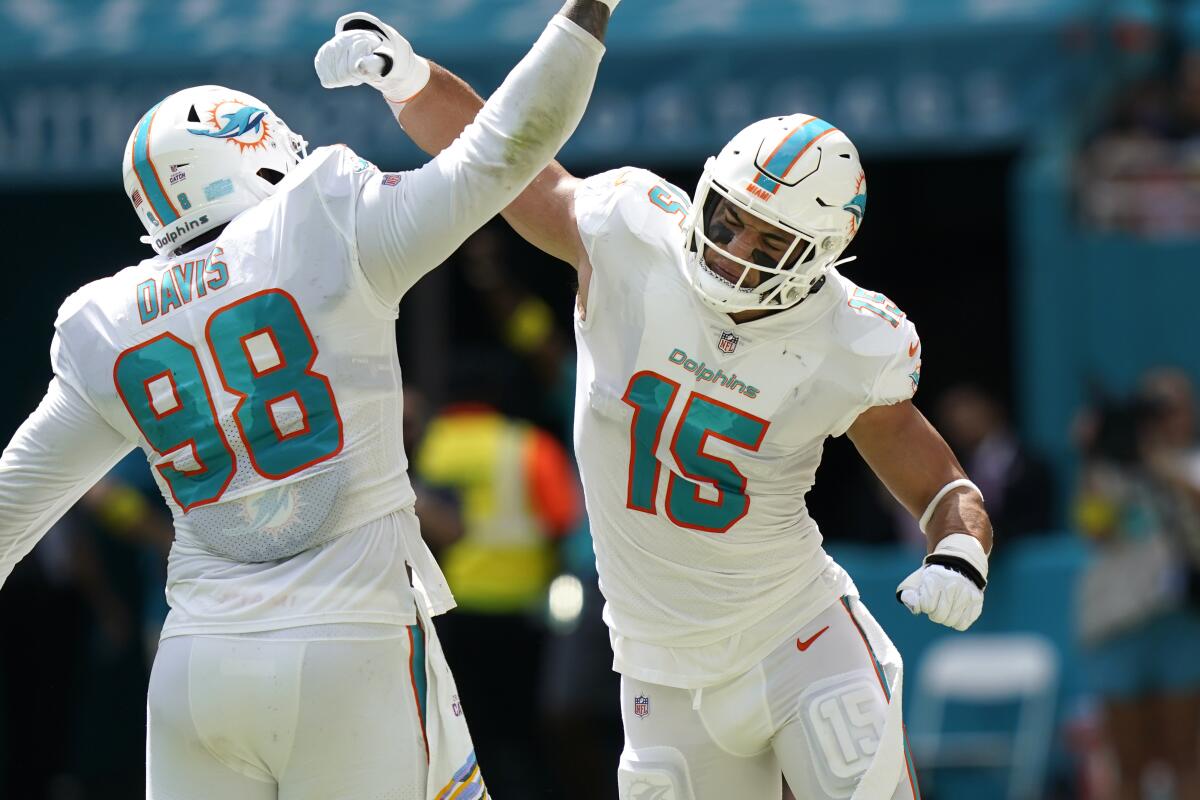 Miami Dolphins linebacker Jaelan Phillips celebrates with defensive tackle Raekwon Davis.