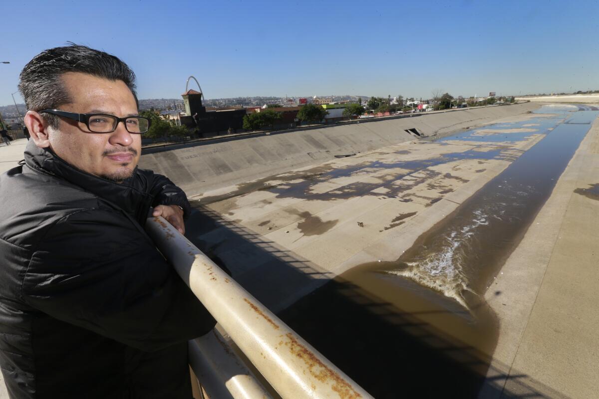 Architect Rene Peralta stands above the Tijuana River. He is proposing a solar farm and green algae cleaning system for the channelized river.