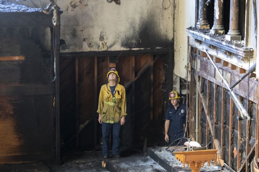 Los Angeles, CA - February 06: Los Angeles City firefighters look over the aftermath of a fire at St. Johns United Methodist Church Sunday, Feb. 6, 2022 in Los Angeles, CA. (Brian van der Brug / Los Angeles Times)