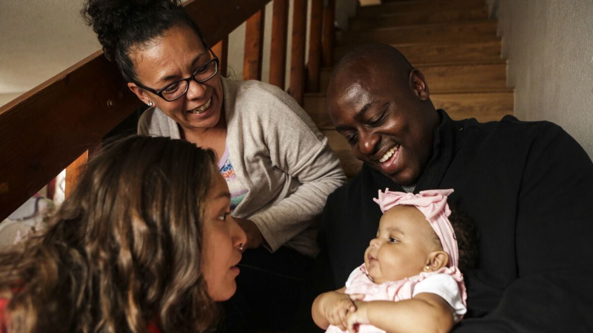 Sylvester Owino with his wife Velia Maria Villanueva, second from left, their 3-month-old daughter Akeyo Itzel Owino and his stepdaughter Miraya Gisel Mandujano in their San Diego home.