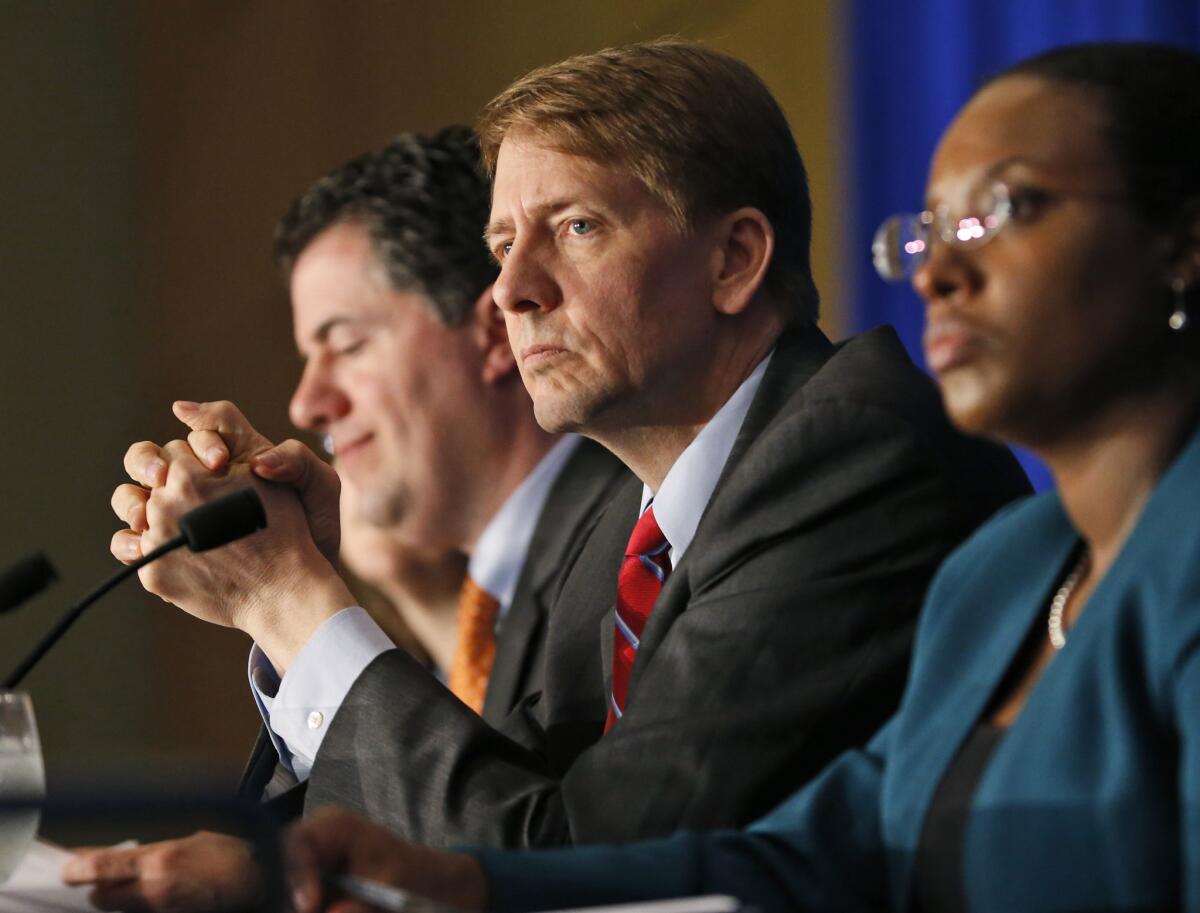 Consumer Financial Protection Bureau Director Richard Cordray, center, listens to comments during a panel discussion in Richmond, Va., on March 26, 2015. The bureau filed a lawsuit against the NDG Enterprise, a payday lender, for collecting money consumers did not owe.
