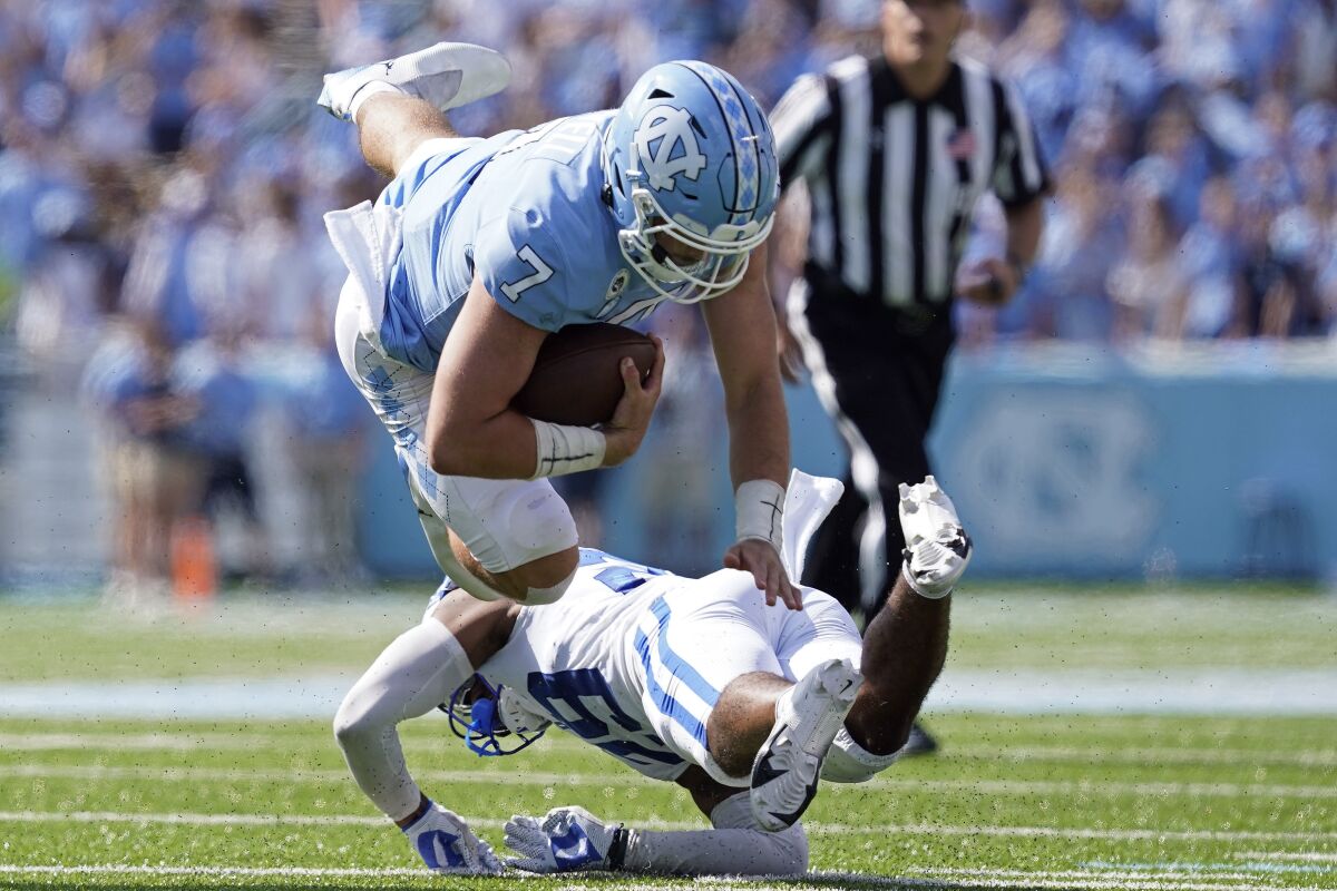 North Carolina quarterback Sam Howell (7) is tackled by Duke linebacker Shaka Heyward (42) during the second half of an NCAA college football game in Chapel Hill, N.C., Saturday, Oct. 2, 2021. (AP Photo/Gerry Broome)