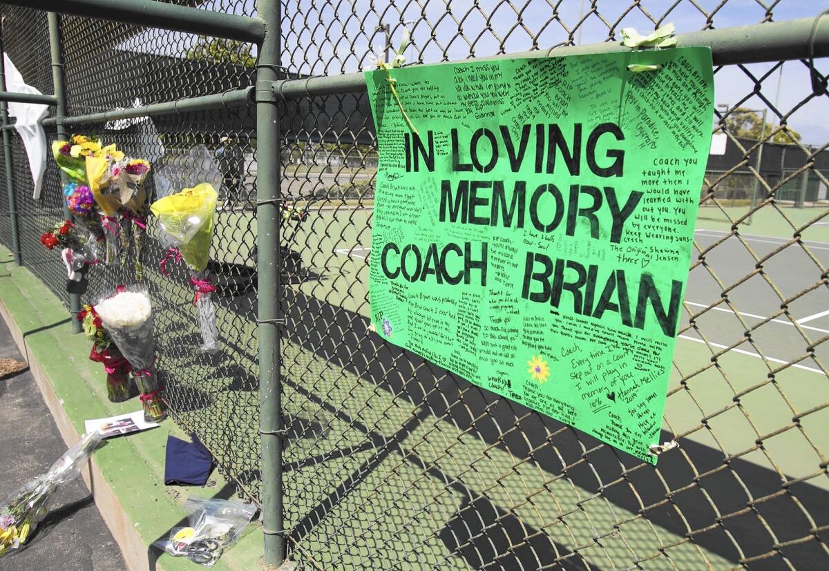 A handmade sign in honor of coach Brian Ricker hangs on a fence before a match on Tuesday afternoon.