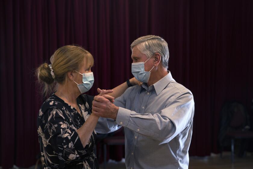 Jutta Graham, izquierda, y Tom Wagoner practican rumba el domingo 14 de febrero de 2021 con mascarillas para protegerse del coronavirus, en The DelRay Ballroom en Lincoln, Nebraska. (Kenneth Ferriera/Lincoln Journal Star vía AP)