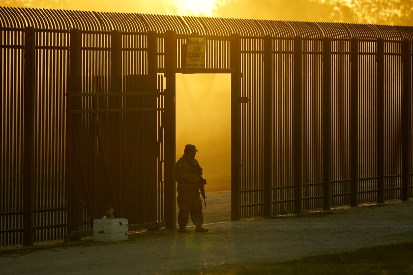 A National Guardsman stands at an opening in the border fence near Del Rio, Texas.