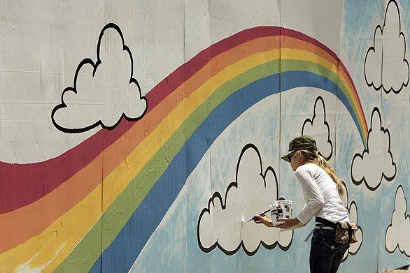 Artist Joella Thomas paints a section of a mural on the construction wall around the new LAPD detention denter in downtown Los Angeles. The 260-foot-long mural, consisting of painted images and photographs of kids, is titled "Do Time at L.A.'s BEST." L.A.'s BEST, which serves more than 26,000 students at 180 schools, celebrates its 20th anniversary this year. The intent of the mural is to bring awareness to the after-school hours between 3 p.m. and 6 p.m. when many students are unsupervised.