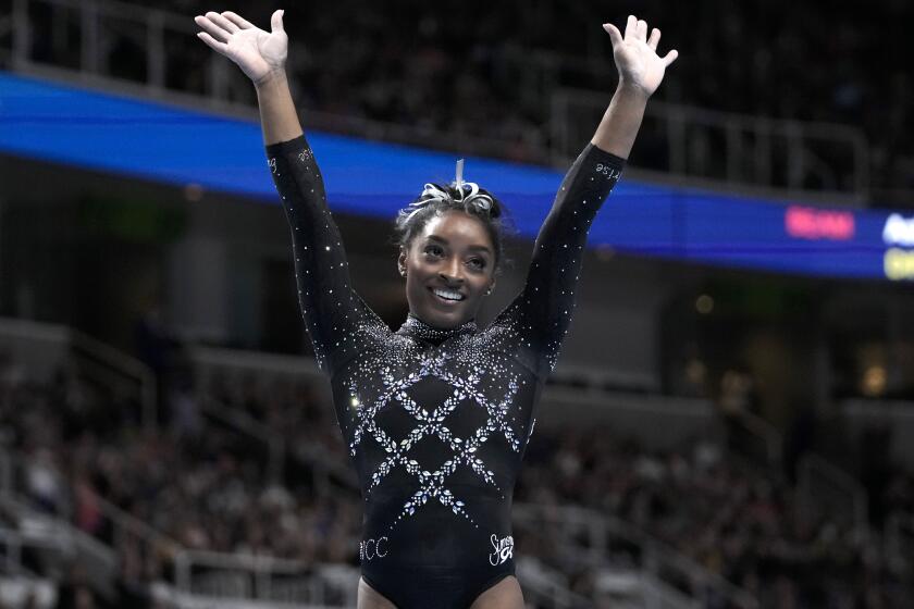 Simone Biles reacts after competing on the floor exercise.