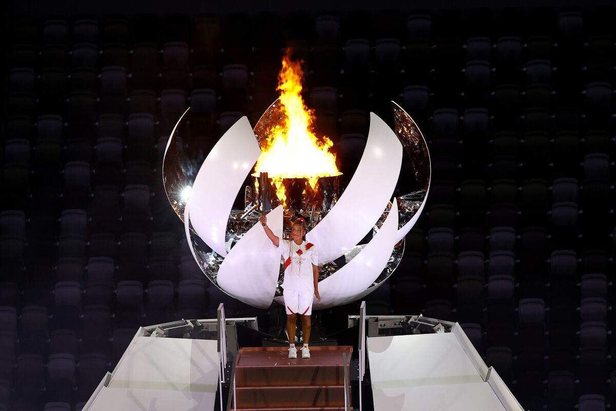 Naomi Osaka of Team Japan holds up the Olympic torch.