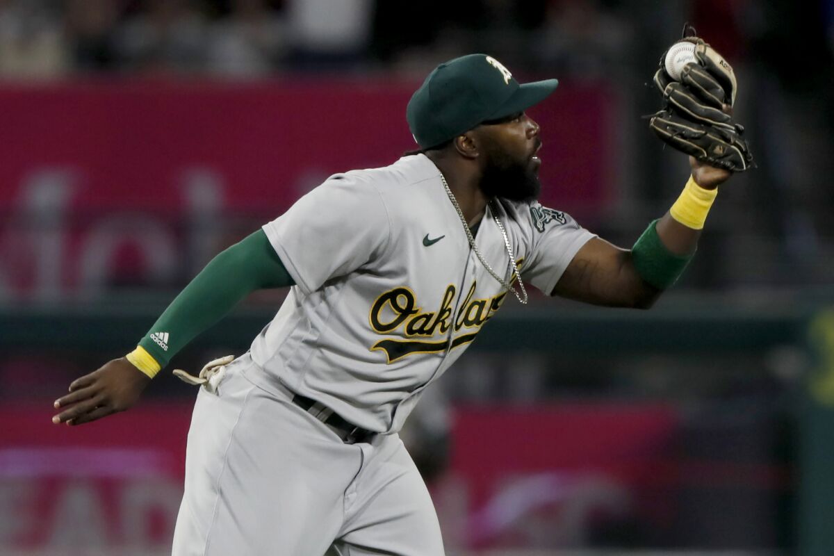 Athletics infielder Josh Harrison looks at the ball after making a game-ending catch against the Angels on Sept. 18, 2021.