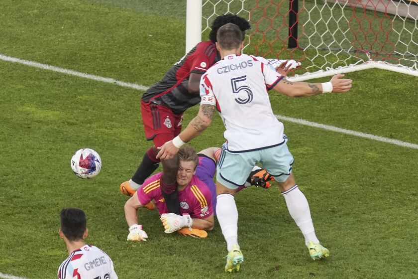 Chicago Fire goalkeeper Chris Brady collides with Toronto FC's Deandre Kerr as Fire defender Rafael Czichos wathes during the first half of an MLS soccer match Wednesday, May 31, 2023, in Toronto. Bradly left the game. (Chris Young/The Canadian Press via AP)