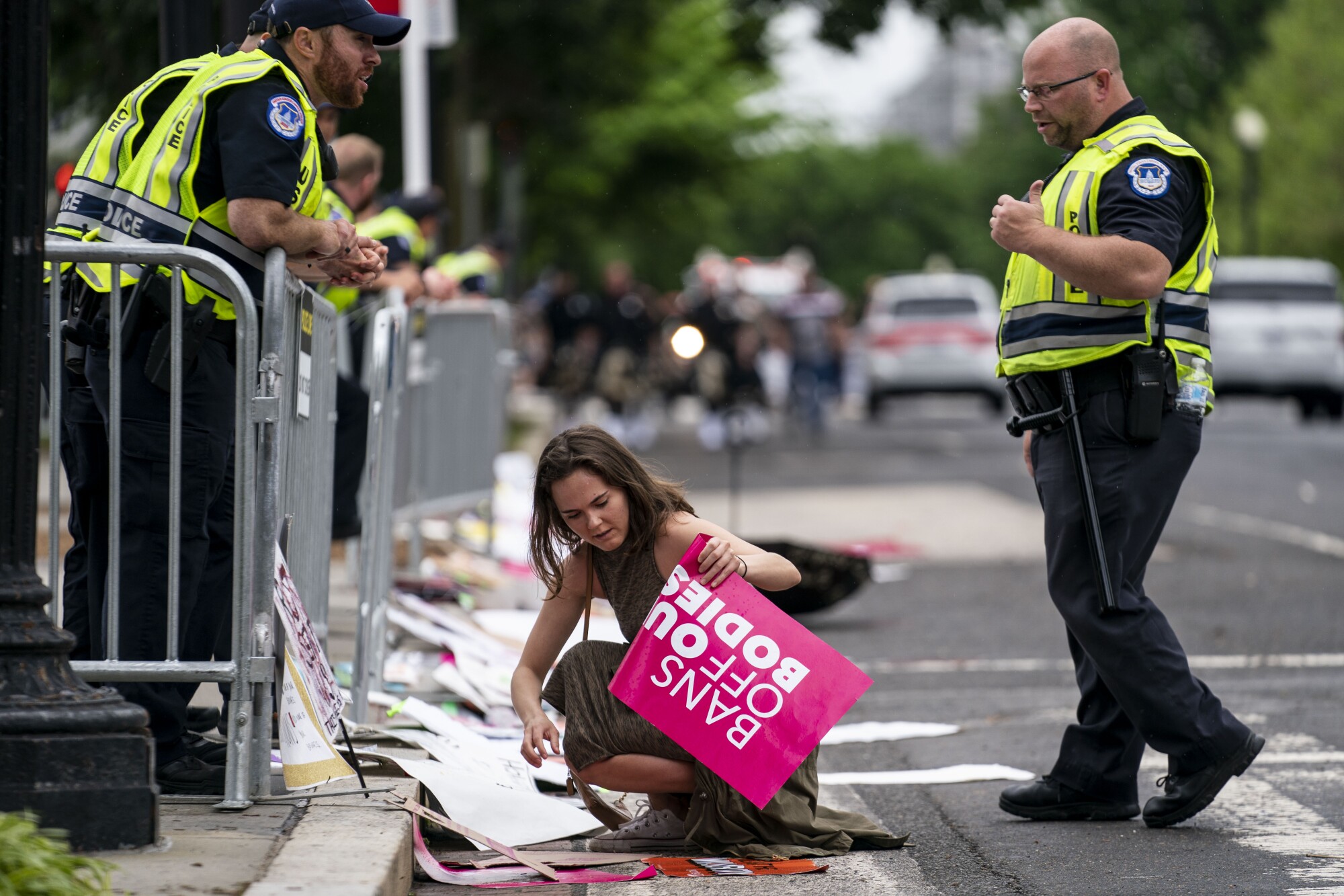    A protester puts signs back on barricades after the signs were removed by Capitol Police officers.