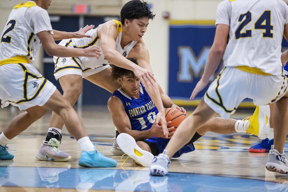 Marina's Kenji Duremdes pressures Fountain Valley's Roddie Anderson during a Wave League boys' basketball game on Tuesday.