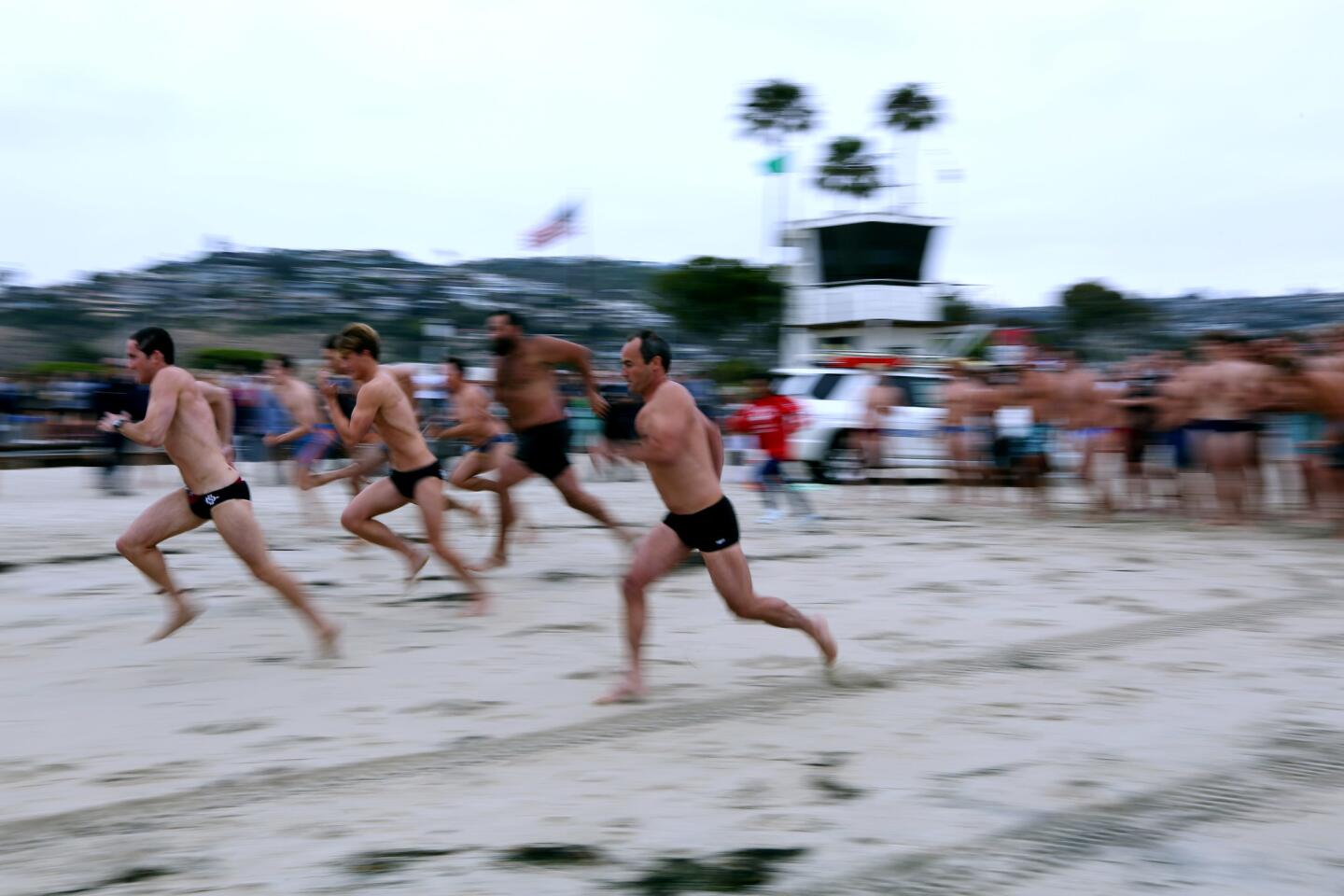 Current and former lifeguards race through the sand in the surf relay competition. Dozens of former Laguna Beach lifeguards convened to celebrate the group’s 90-year anniversary at the main beach tower in Laguna Beach on Saturday.