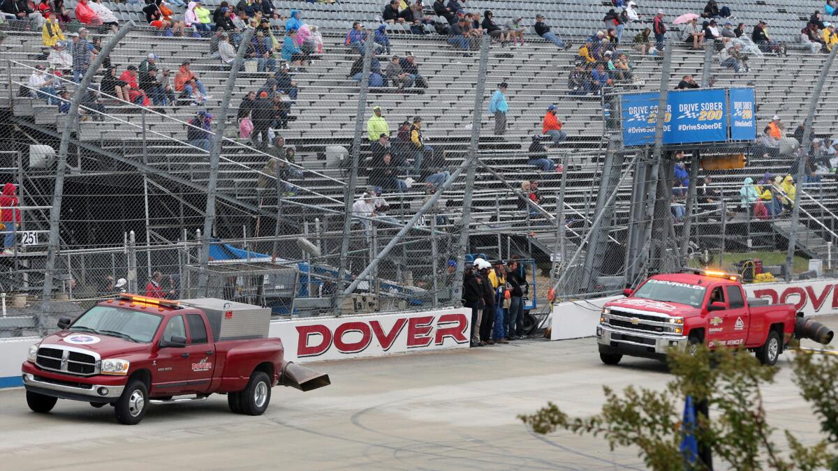 Trucks with jet dryers circle the track at Dover on Saturday, but continued rain forced postponement of the Xfinity Series race to Sunday.