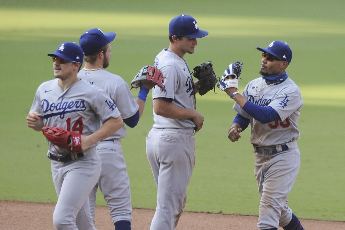 Dodgers shortstop Corey Seager congratulates right fielder Mookie Betts, right, near center fielder Kiké Hernandez (14)
