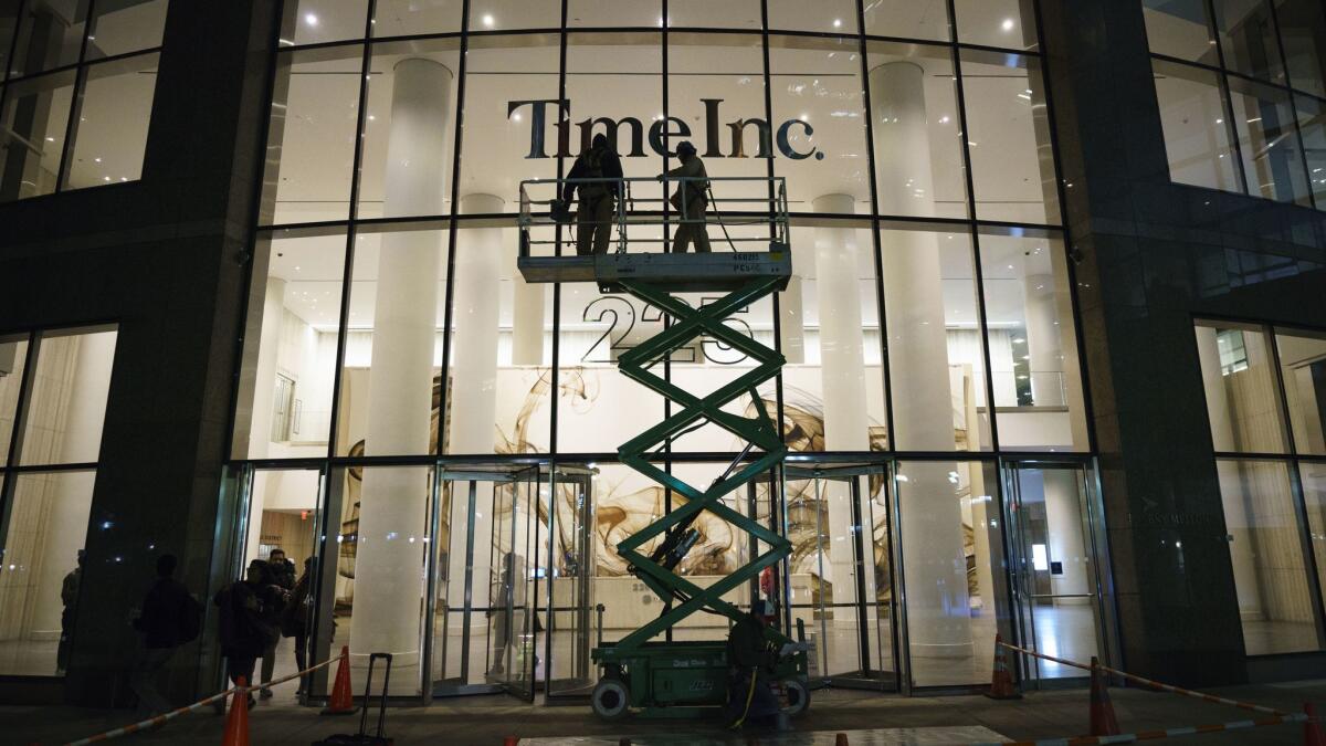 Workers prepare to cover up the Time Inc. signage with Meredith Corporation signage at the Time Inc. office building in New York City on Jan. 31.