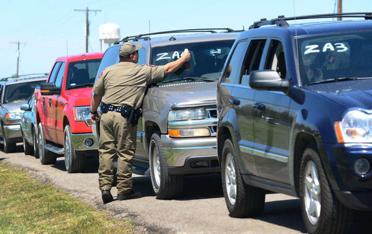 A Texas highway patrol officer marks a vehicle Saturday as residents are allowed to return temporarily to their destroyed homes near the site of the fertilizer plant blast in West, Texas.