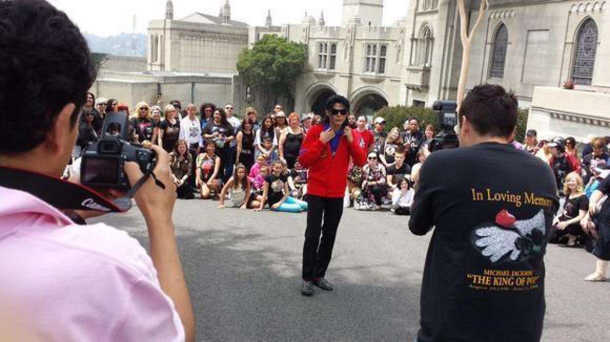 Michael Jackson impersonator Carlo Riley poses for fans at Forest Lawn Memorial Park on Tuesday.