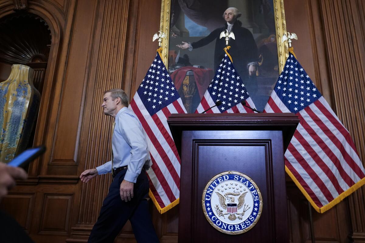 A man leaves a podium with the U.S. Congress seal on it and U.S. flags behind him.