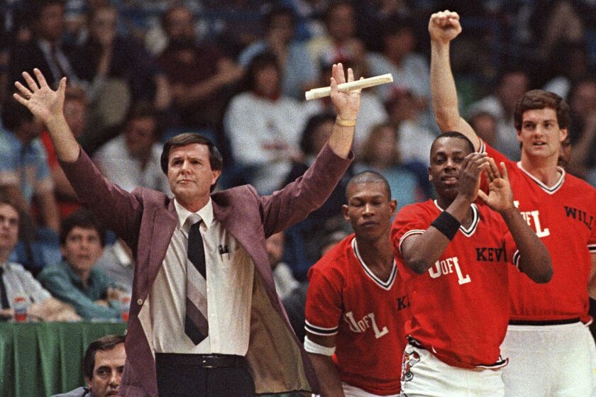 FILE - Louisville coach Denny Crum gestures towards his team as players from the bench begin to celebrate during the closing moments of their 88-77 victory over LSU in the NCAA college basketball semifinals in Dallas, March 29, 1986. Denny Crum, who won two NCAA men’s basketball championships and built Louisville into one of the 1980s’ dominant programs during a Hall of Fame coaching career, died Tuesday, May 9, 2023. He was 86. (AP Photo/David Longstreath, File)