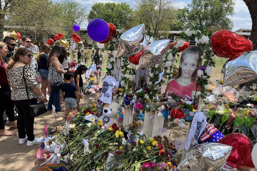 A memorial outside the Uvalde elementary school features life size photos of the 19 children killed.