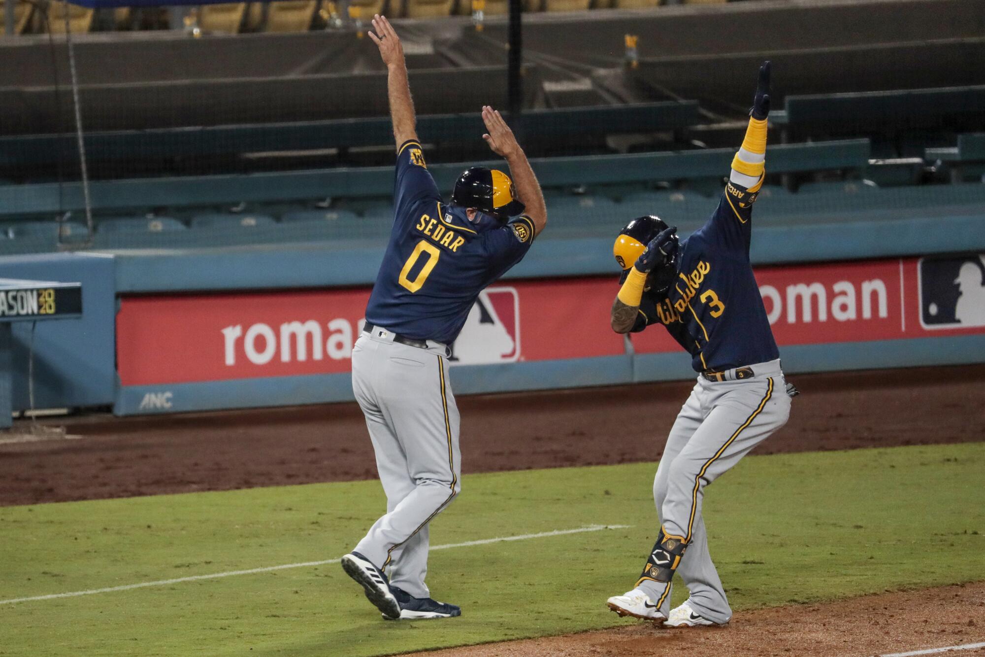 Milwaukee Brewers shortstop Orlando Arcia, right, celebrates with third base coach Ed Sedar after hitting a two-run homer.