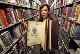 LOS ANGELES, CA-SEPTEMBER 13, 2018: Susan Orlean, who has an upcoming book about the LA Public Library and the mysteries surrounding its devastating 1986 fire, is photographed next to books in the library's history dept. She is holding a book that was damaged in the fire. (Mel Melcon/Los Angeles Times)