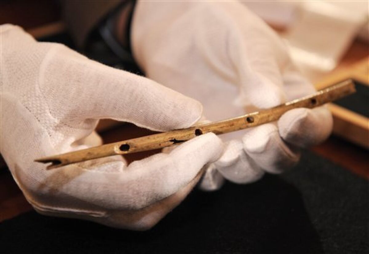 Professor Nicholas Conard of the University in Tuebingen shows a flute during a press conference in Tuebingen, southern Germany, on Wednesday, June 24, 2009. The thin bird-bone flute carved some 35,000 years ago and unearthed in a German cave is the oldest handcrafted musical instrument yet discovered, archeologists say, and offers the latest evidence that early modern humans in Europe had established a complex and creative culture. A team led by Conard assembled the flute from 12 pieces of griffon vulture bone scattered in a small plot of the Hohle Fels cave in southern Germany. (AP Photo/Daniel Maurer)