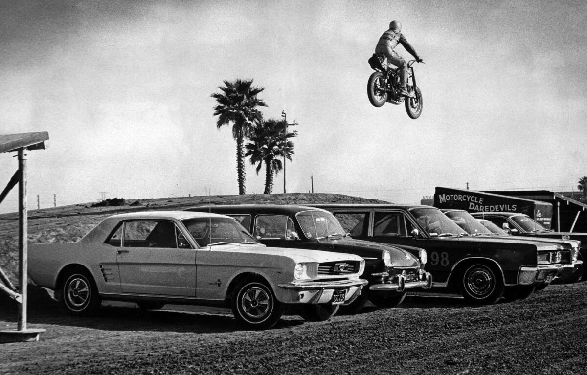 March 3, 1967: Motorcycle stuntman Evel Knievel soars over tops of cars during practice jump at Gardena's Ascot Park. Knievel's jump was held before the 100-lap Grand Prix steeplechase.