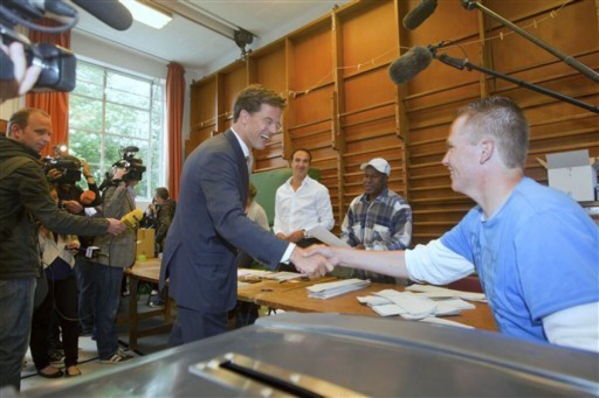 Conservative VVD party leader Mark Rutte shakes hands with a member of staff, prior to casting his ballot for the general election, in The Hague, Netherlands, Wednesday June 9, 2010. Polls opened Wednesday in the Netherlands where Dutch voters will elect a new parliament after an election campaign focused on economic and immigration policy. The conservative VVD party and its leader Mark Rutte are leading in opinion surveys on a deficit-busting, tough-on-immigration platform. The anti-Islam Freedom Party and its leader Geert Wilders also hope to book large gains. (AP Photo/Evert-Jan Daniels)