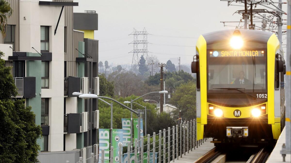 A Metro train passes by apartments in Culver City.