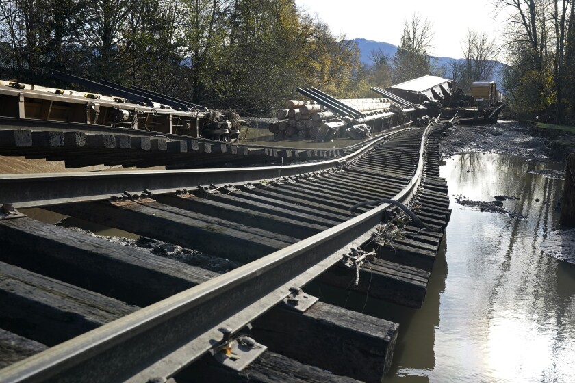 Derailed railroad cars sit near flood-damaged tracks at a BNSF rail yard Wednesday, Nov. 17, 2021, in Sumas, Wash. An atmospheric river—a huge plume of moisture extending over the Pacific and into Washington and Oregon—caused heavy rainfall in recent days, bringing major flooding in the area. (AP Photo/Elaine Thompson)
