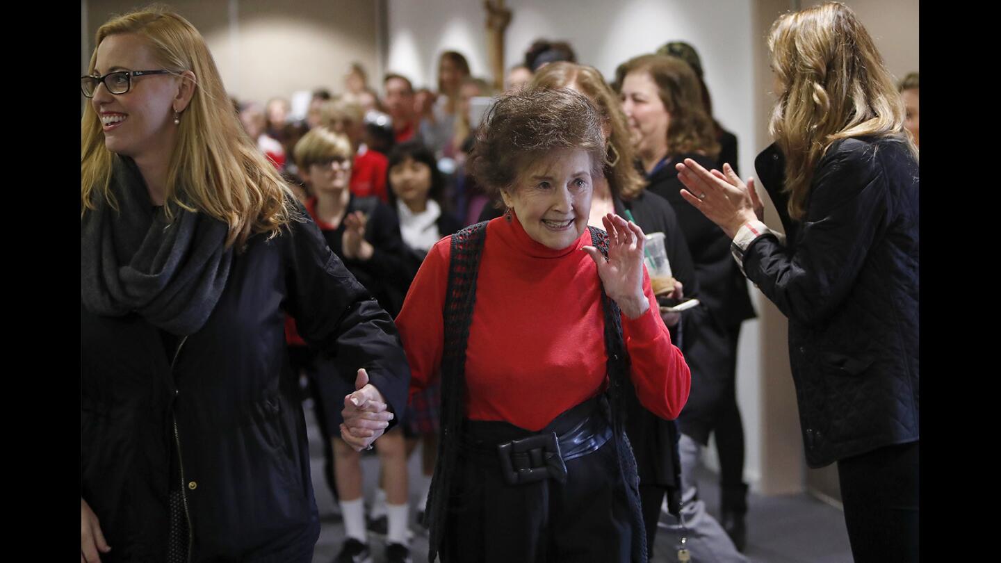 Donna Custer smiles as she walks into a surprise 90th-birthday celebration by teachers, students and faculty at Our Lady Queen of Angels Catholic School in Newport Beach on Monday. Custer, a former dancer and actress whose stage name was May Wynn, is an aide at the school.