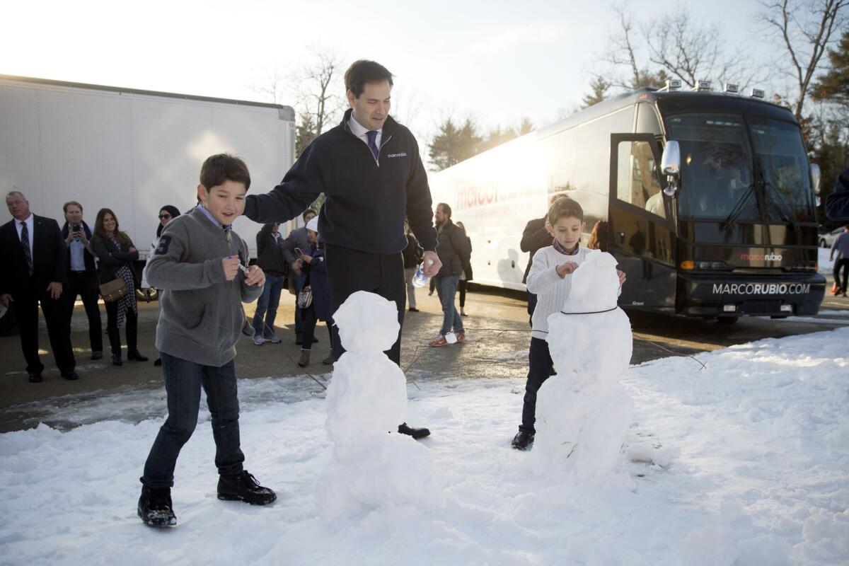 Sen. Marco Rubio with the snowmen that his sons Anthony, 10, left, and Dominick, 8, built on the campaign trail in Hudson, N.H.