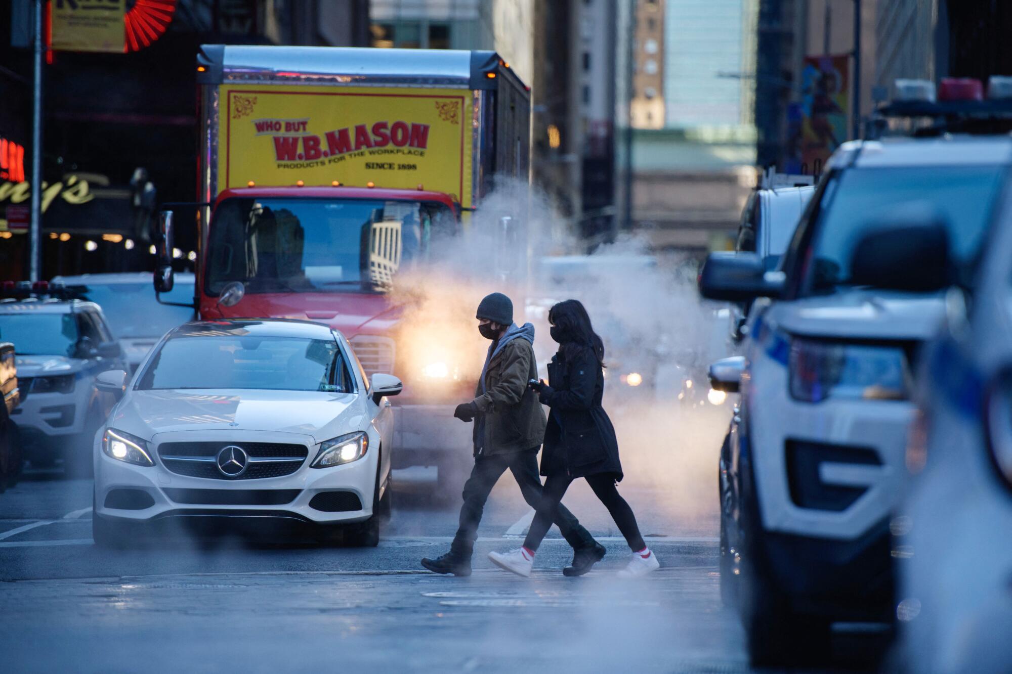 People cross a street in New York