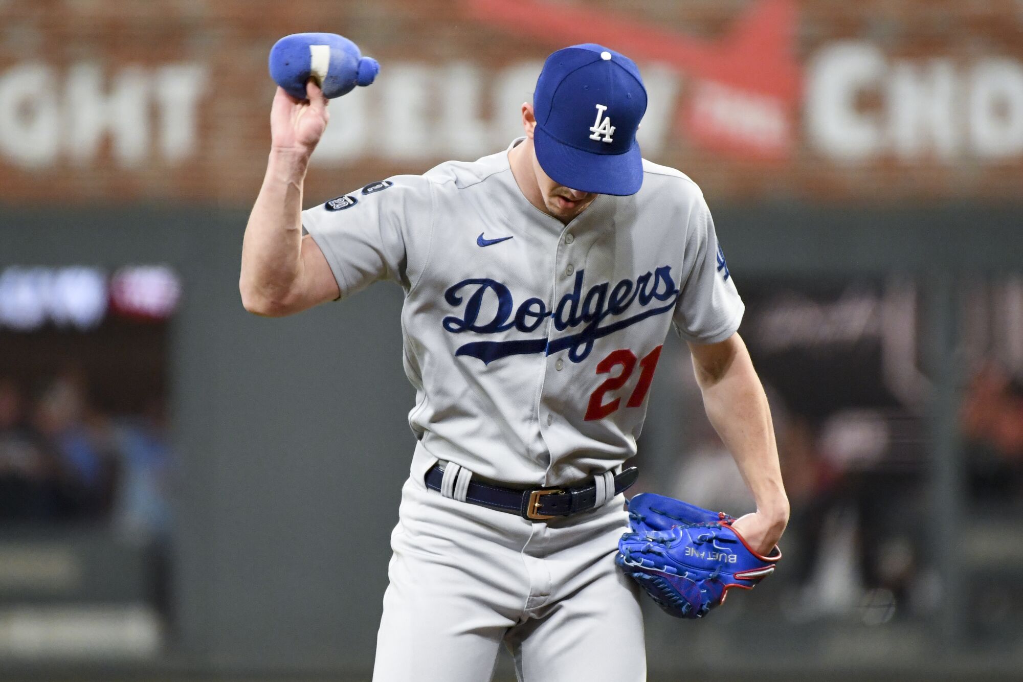 Dodgers starting pitcher Walker Buehler reacts after giving up an RBI double to Braves' Austin Riley.
