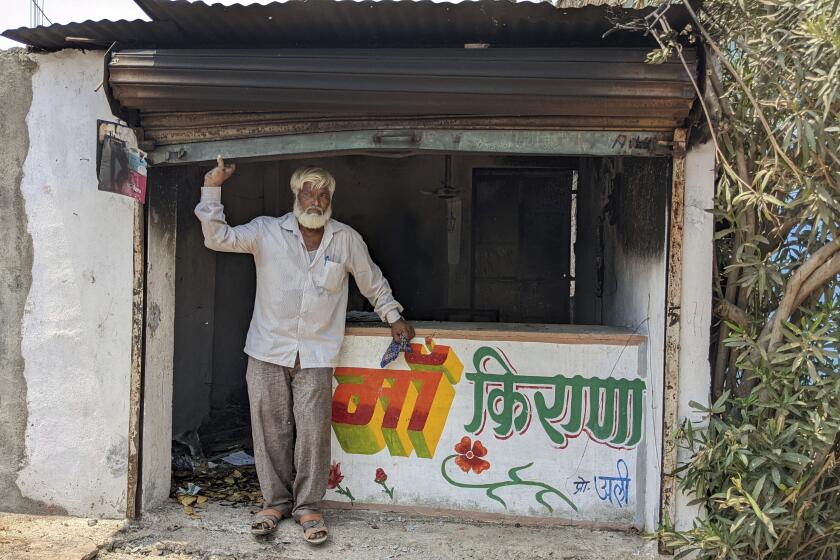 Nawab Khan stands by the entrance of his shop vandalized by a mob on April 10 in Khargone, in the central Indian state of Madhya Pradesh, Tuesday, April 12, 2022. On April 10, a Hindu festival marking the birth anniversary of Lord Ram turned violent in Khargone after Hindu mobs brandishing swords and sticks marched past Muslim neighborhoods and mosques. Videos showed hundreds of them dancing and cheering in unison to songs blared from loudspeakers that included calls for violence against Muslims. (AP Photo/Kashif Kakvi)