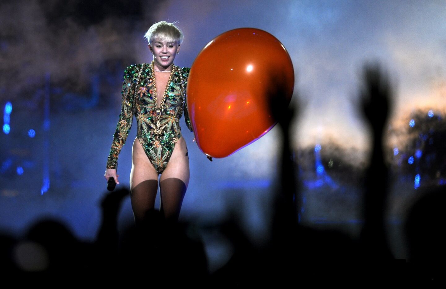 Miley Cyrus clutches a large red balloon -- just one of her props for the evening.