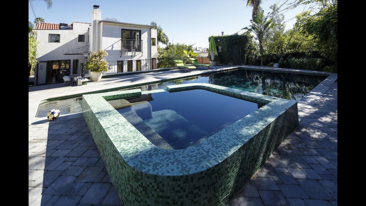 Designer Cobbet added a Juliet balcony outside the master suite and multiple windows and doors to the rear of the house. Babylon Pools of Glendale refurbished the pool deck with pavers and added an elevated spa clad in glass mosaic tiles.