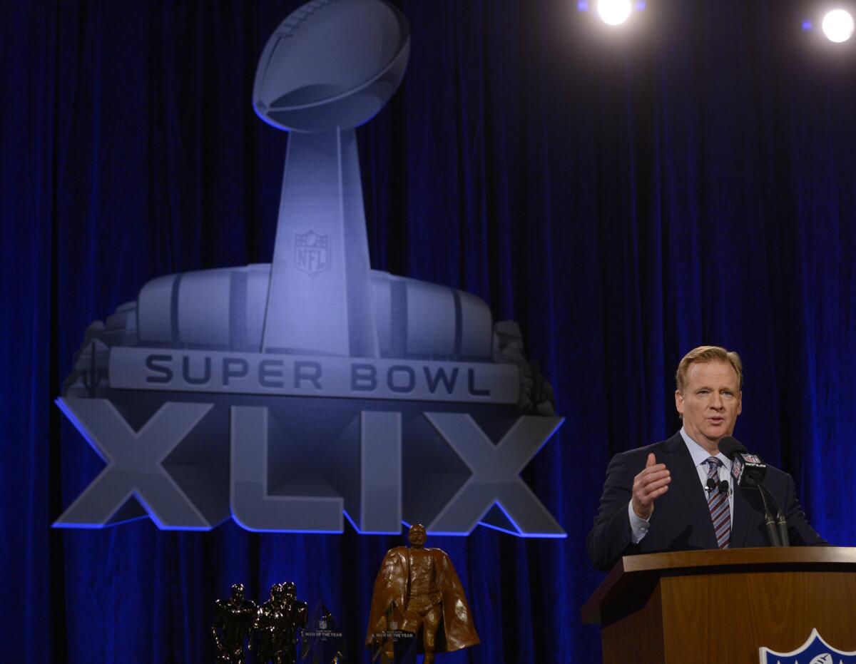 NFL Commissioner Roger Goodell speaks at an NFL podium during a news conference before Super Bowl XLIX in Phoenix.