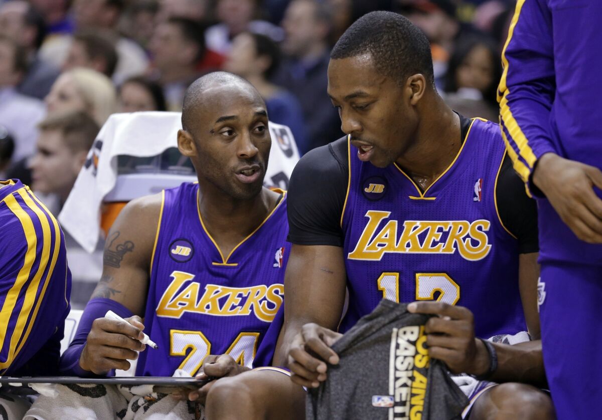 Lakers guard Kobe Bryant, left, draws up a play for center Dwight Howard last season.