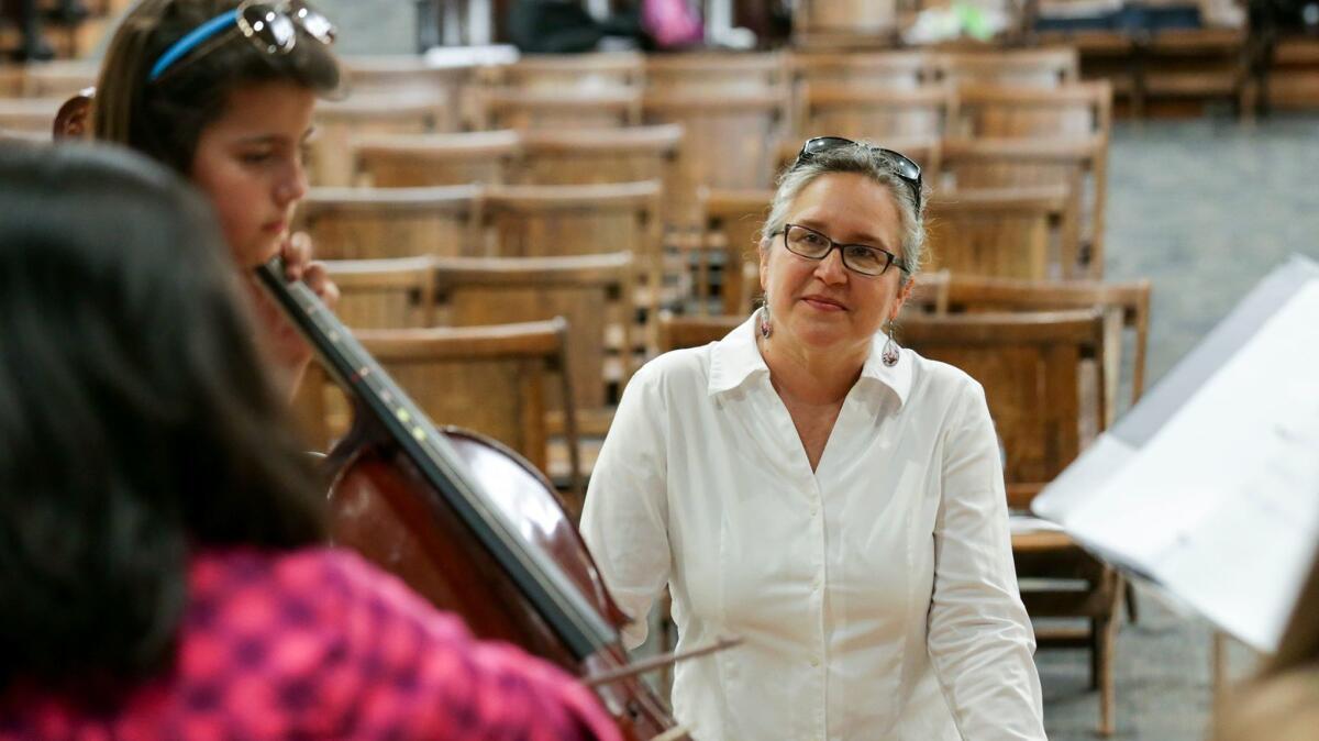 Angie Uriu, program manager of the Harmony Project, works with summer school students in a music class at Webster Elementary School in Pasadena. The school is a feeder to Eliot Middle.