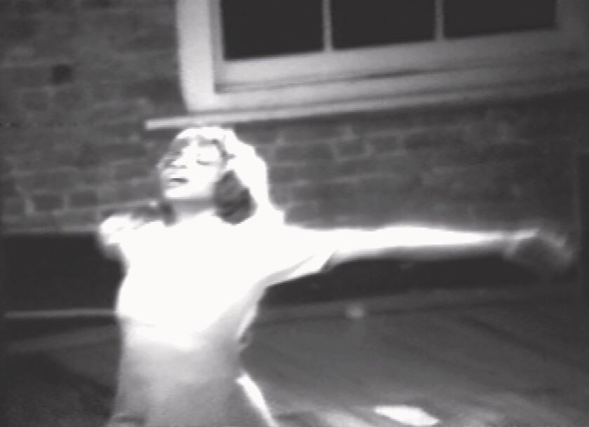 A woman spreads her arms wide in a black-and-white still from "The Ladies and Me," 1980. 